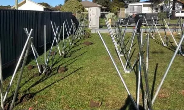 Adjustable ALLFOOT footings installed in a grassy area showing versatile X-shaped metal support structures